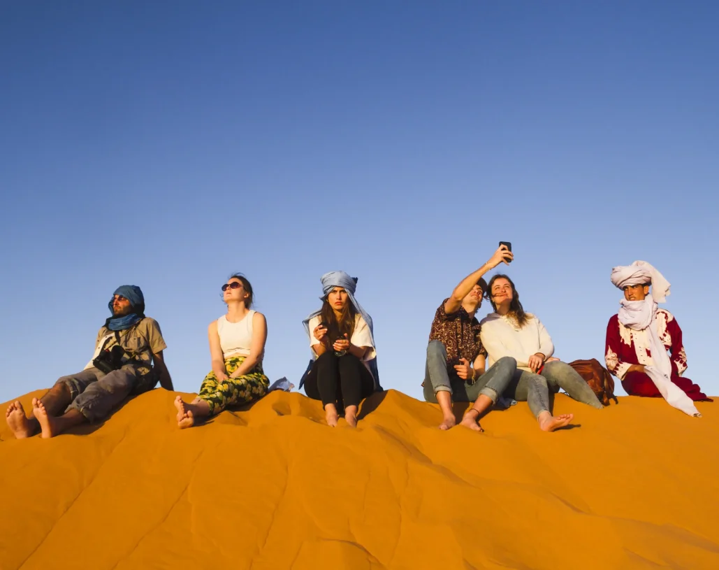 group-people-sitting-top-dune